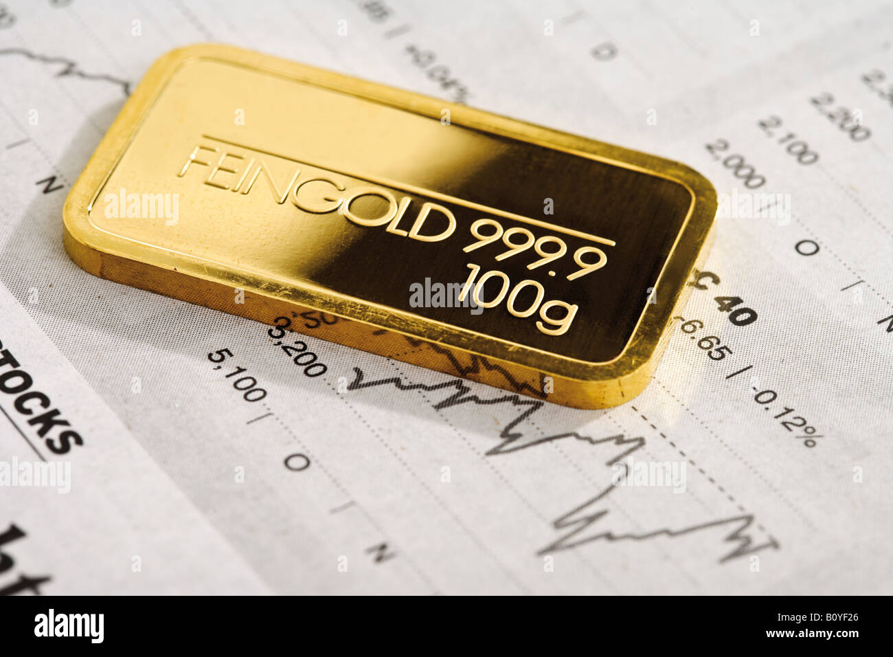 Goldbarren und Finanzzeitung Stockfoto