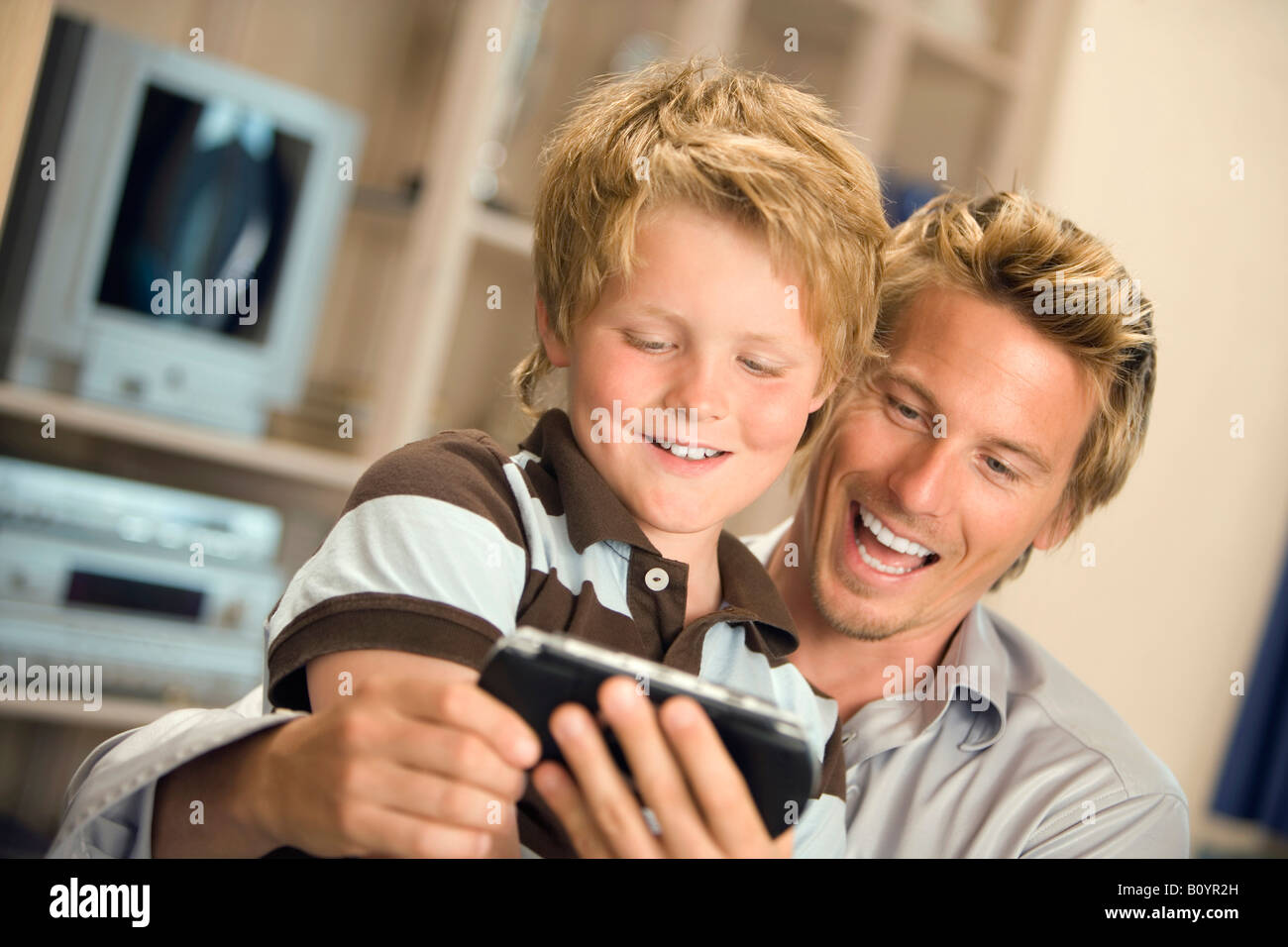 Vater und Sohn (10-11) Blick auf Handy zusammen Stockfoto