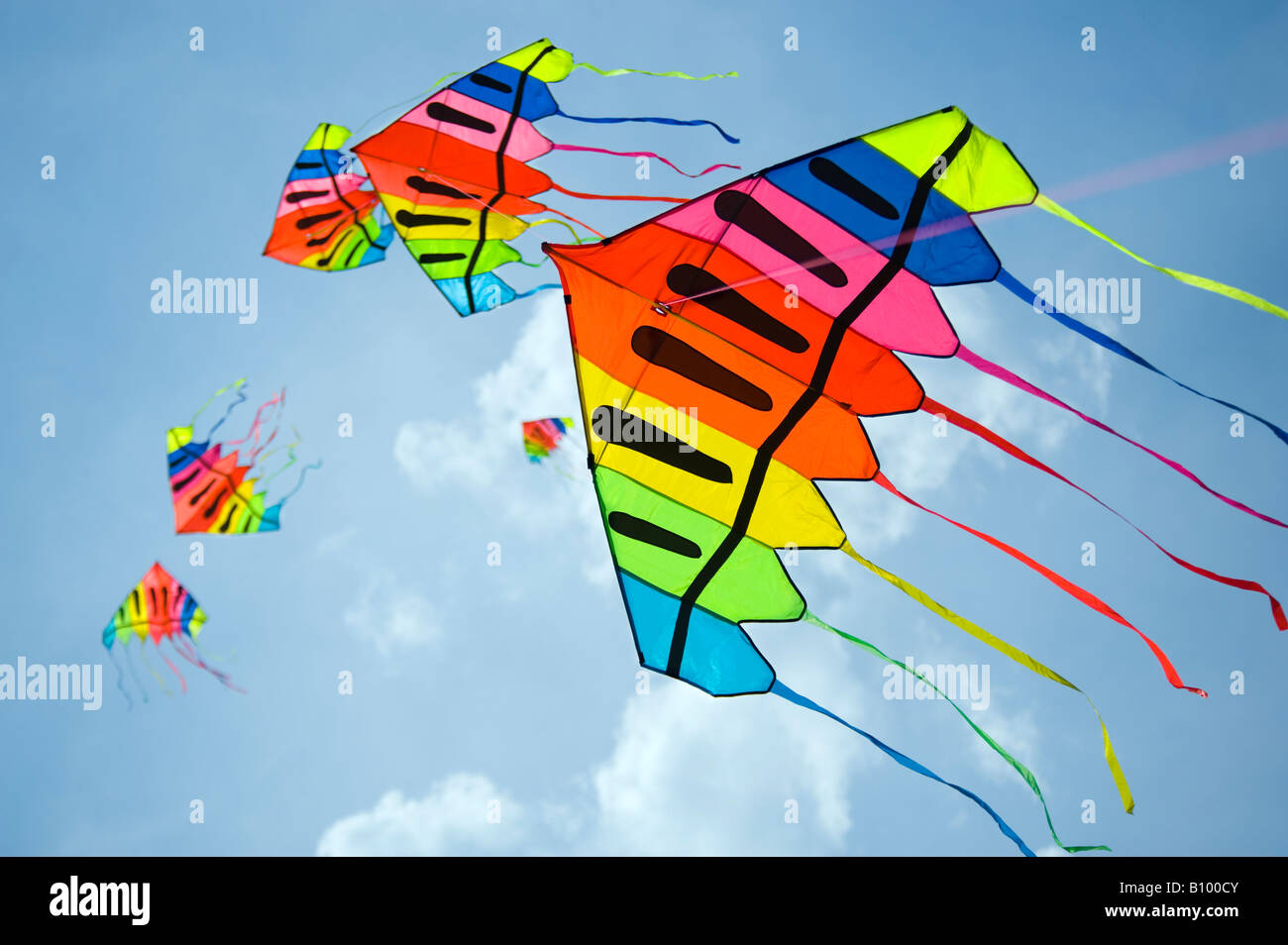 Static-Line-Drachen fliegen gegen einen blauen und bewölkten Himmel Stockfoto