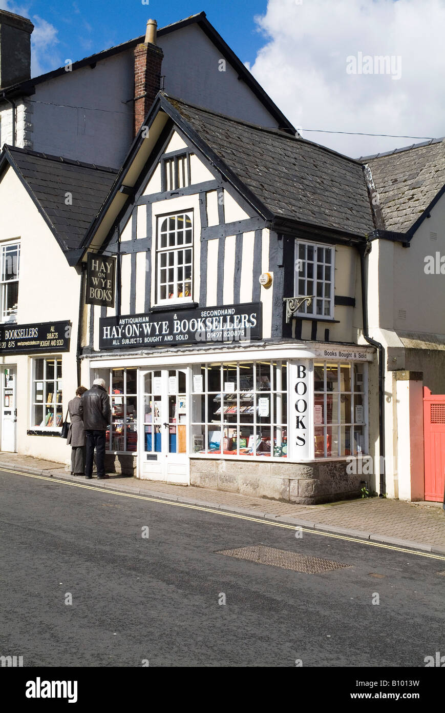 dh Hay on Wye Buchhandlungen POWYS WALES Menschen suchen in Buchhandlung buchstadt Schaufenster Shopper Stadt Shop Touristen Buchhandlungen Buchhandlung Stockfoto