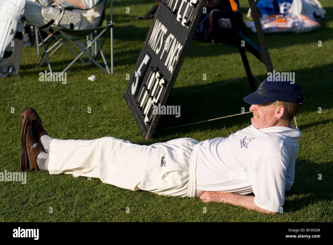 Cricket-Spieler beobachtet eine Spiel aus der Seitenlinien Stockfoto