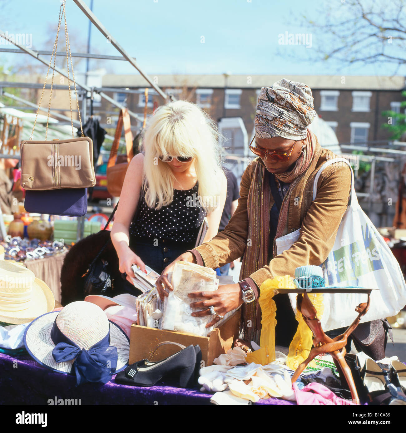 Zwei junge Frauen suchen durch Kleid nähen Muster auf einem Greenwich vintage Markt in London England UK KATHY DEWITT Abschaltdruck Stockfoto