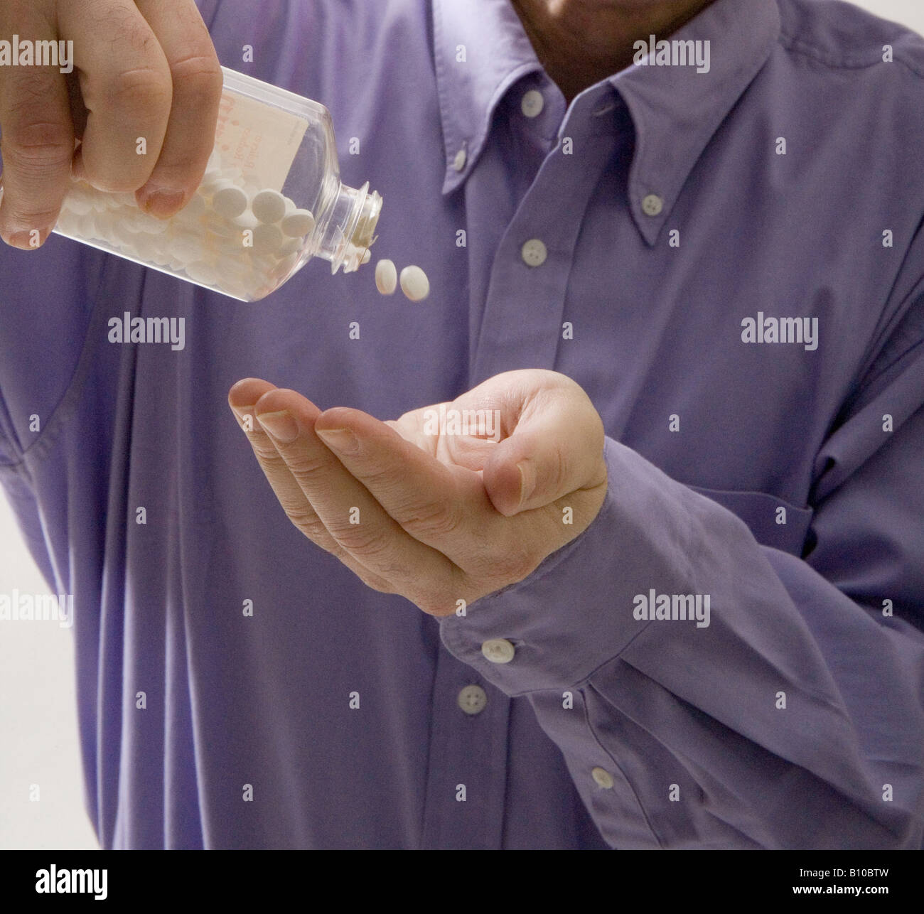 Man gießt Aspirin aus Flasche in seine Hände. Stockfoto