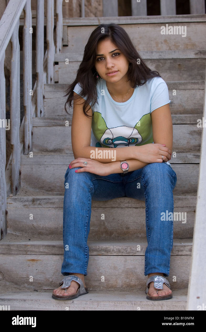 Vorderansicht Porträt einer schönen ethnische Frau sitzt auf der Treppe im freien Stockfoto