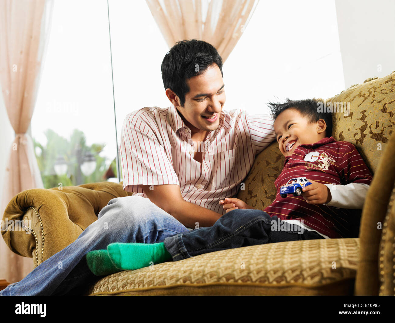Ein Junge wird kitzeln von Vater Stockfoto