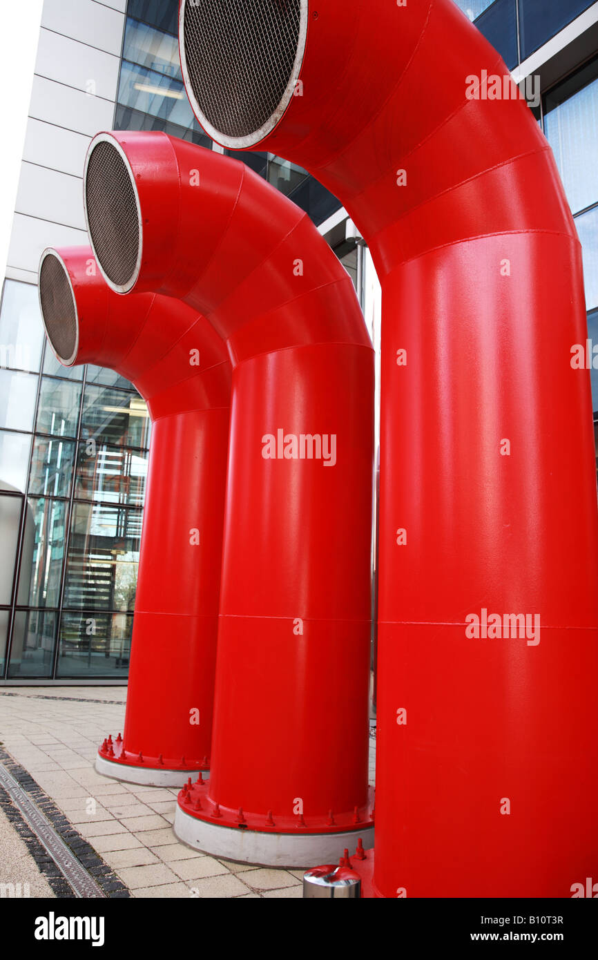 Lüftungsöffnungen als drei große rote Röhren in einem modernen Gebäude Stockfoto