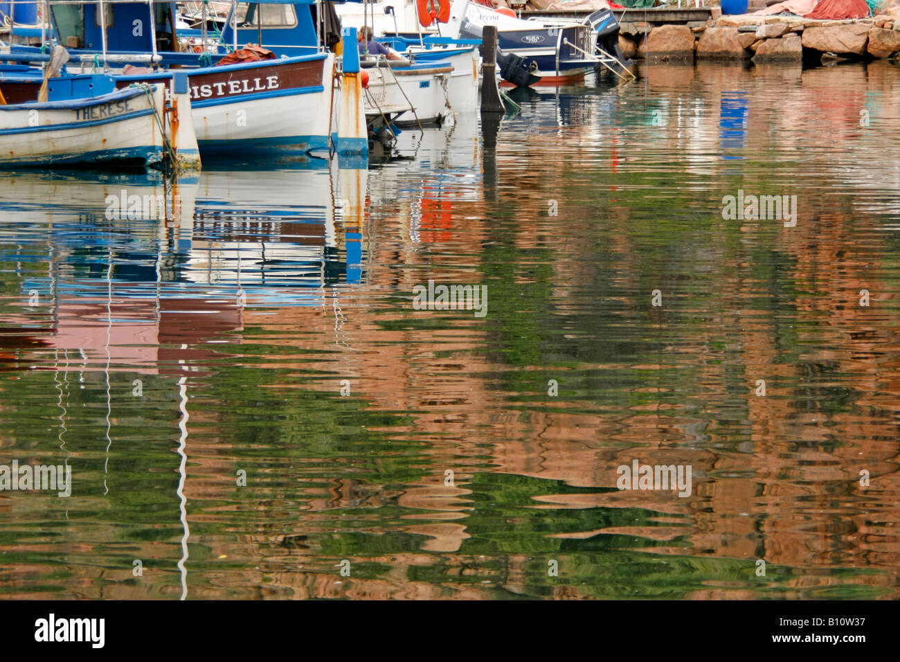 Angelboote/Fischerboote im Wasser der Marina in Porto Korsika Frankreich widerspiegelt Stockfoto