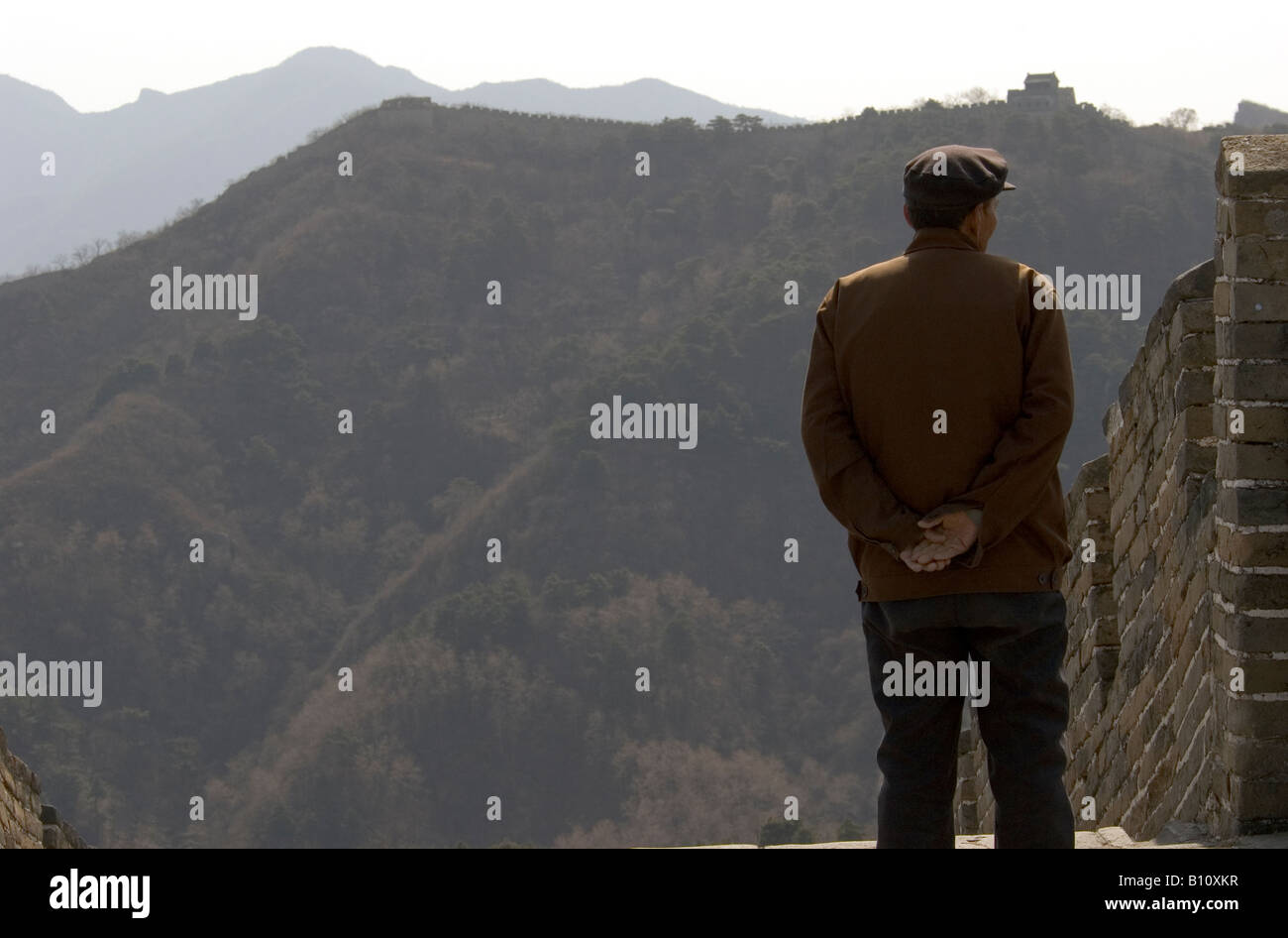 Traditionell gekleidete chinesische Senioren (Mann), Blick auf Mauer (Mutianyu Abschnitt) am frühen Morgen. Stockfoto