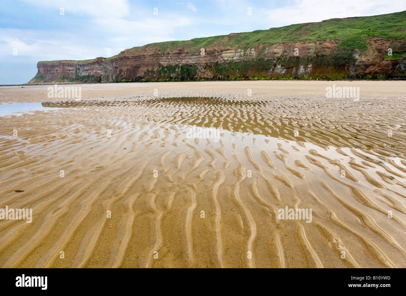 Wellige Sand am Strand von Saltburn mit Huntcliff in der Ferne. Saltburn-by-the-Sea, North Yorkshire, Großbritannien Stockfoto