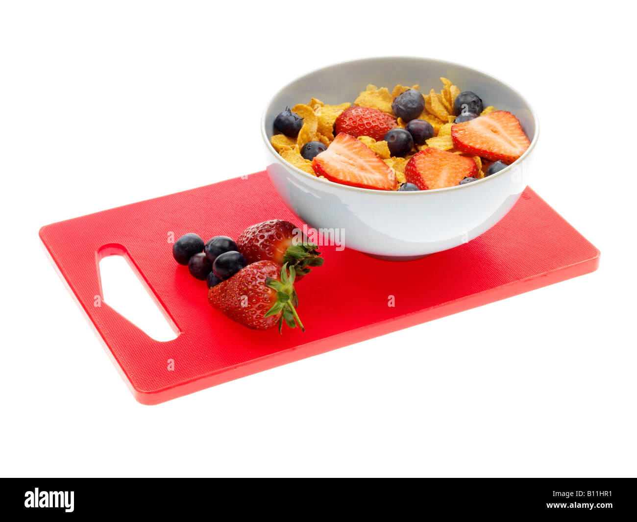 Frische Schale mit gesunden Cornflakes Müsli mit Erdbeeren und Blaubeeren Isoliert gegen einen weißen Hintergrund mit Keine Personen Stockfoto