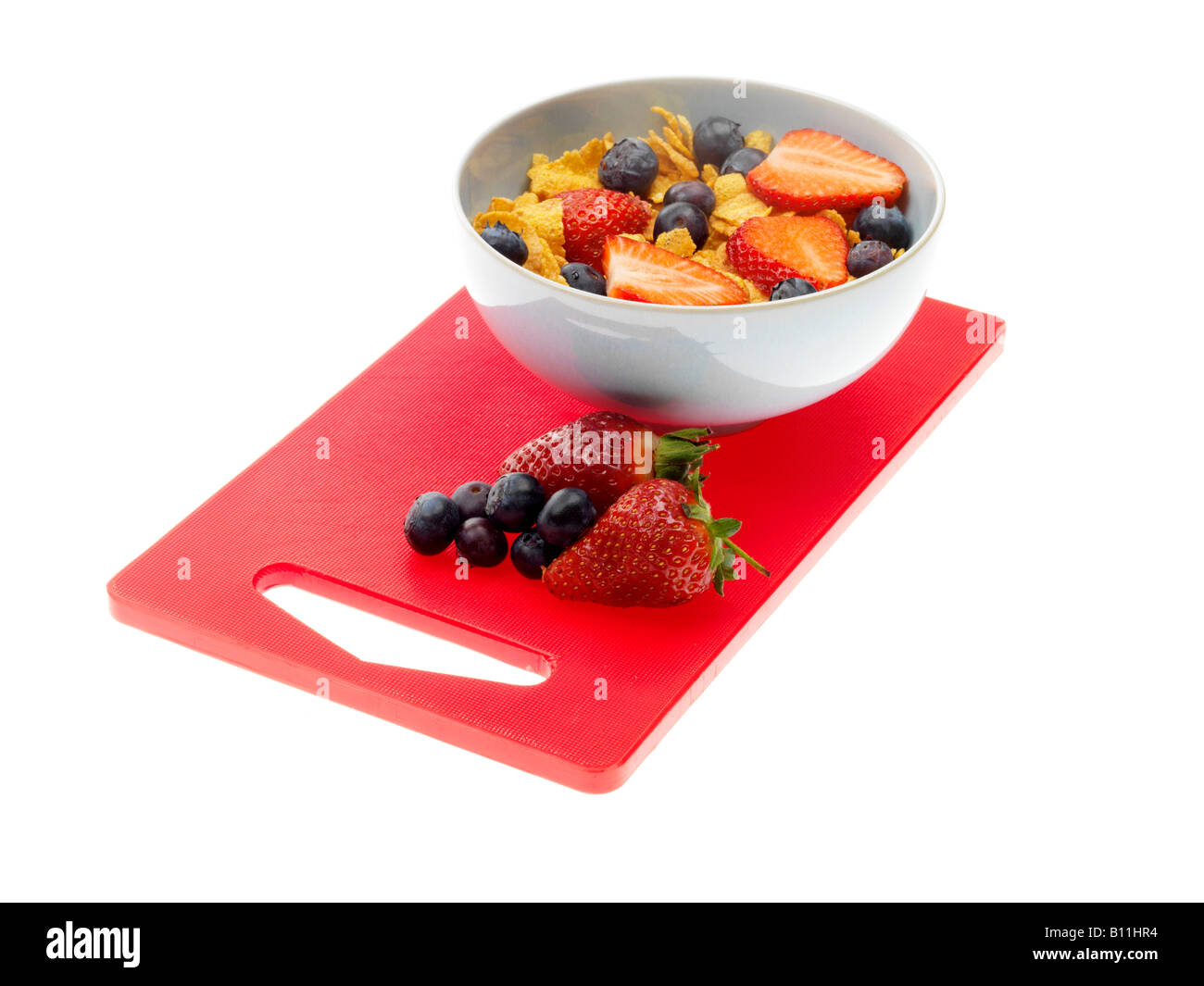 Frische Schale mit gesunden Cornflakes Müsli mit Erdbeeren und Blaubeeren Isoliert gegen einen weißen Hintergrund mit Keine Personen Stockfoto