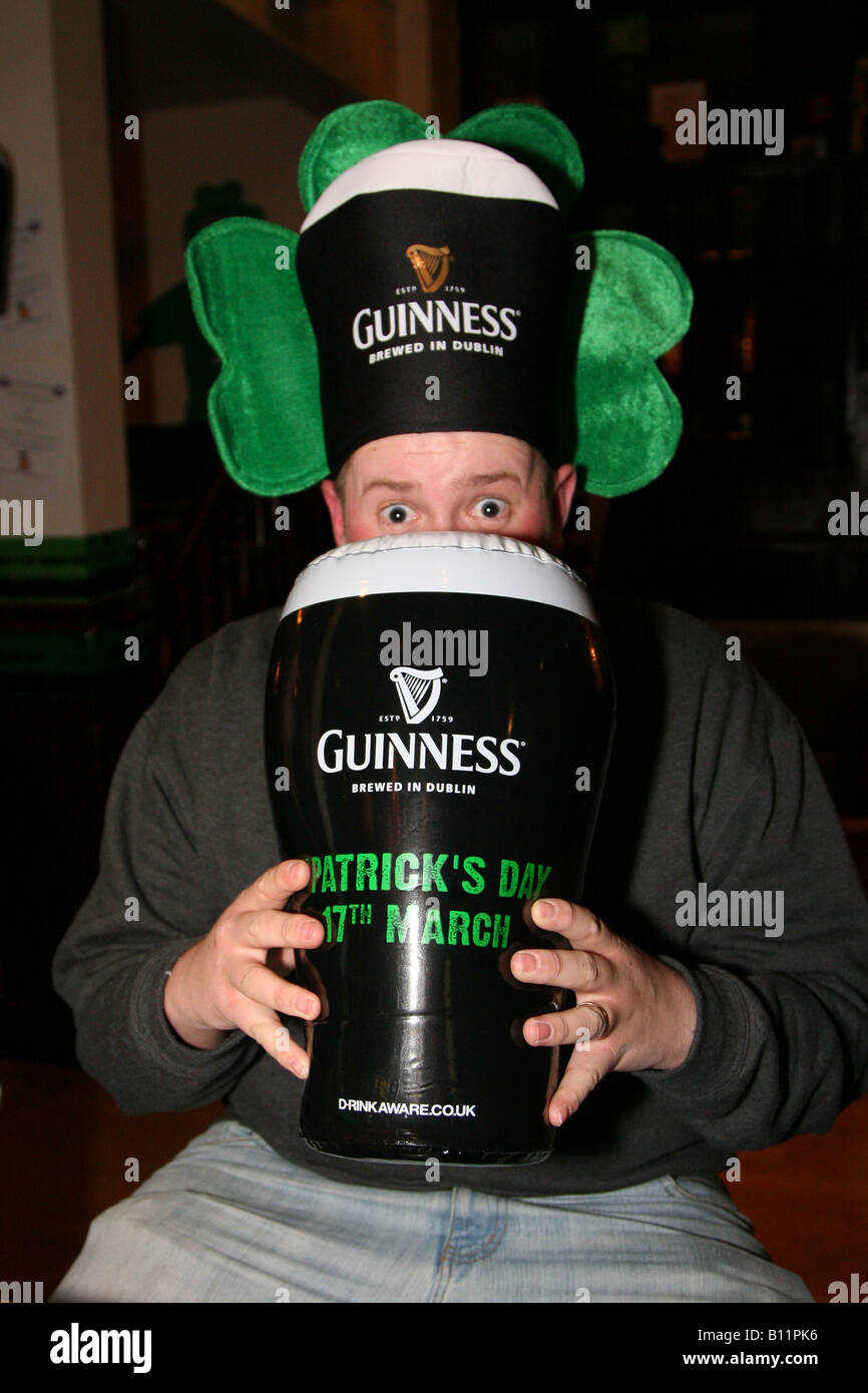 Porträt des Menschen feiern St. Patricks Day mit aufblasbaren Pint Guinness und albernen Hut Stockfoto