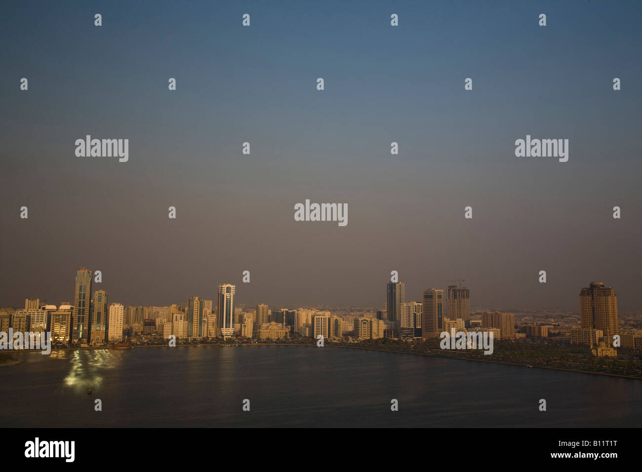 Landschaftlich von der Sharjah Corniche in den Vereinigten Arabischen Emiraten VAE im Nahen Osten in der Abenddämmerung Stockfoto