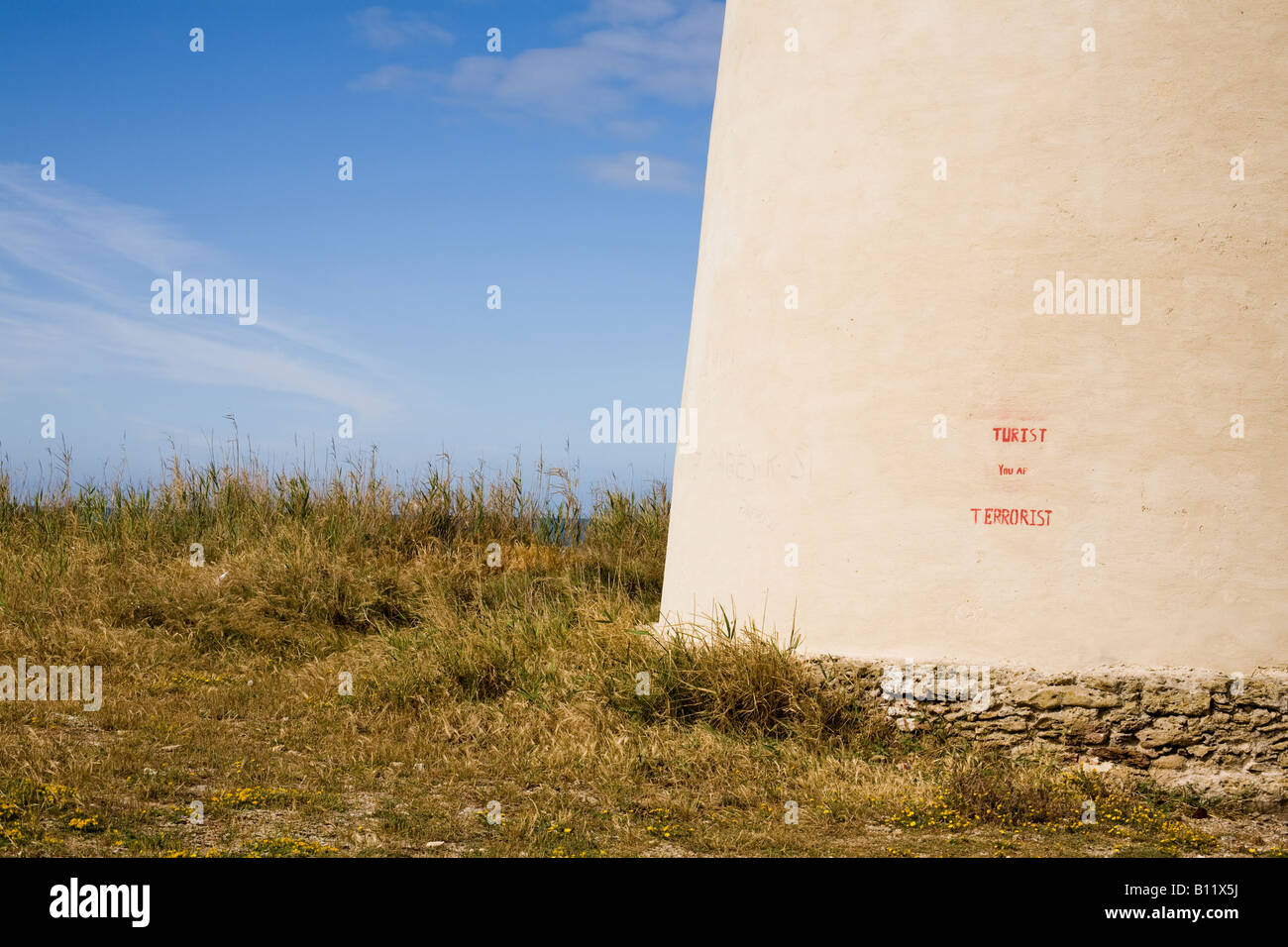 Graffiti auf dem Torre Nueve - der Neue Turm - ein alter Aussichtsturm und Verteidigungsturm am Ufer von El Palmar lautet "TURIST YOU AR TERRORIST". Playa de El Palmar, El Palmar, Vejer de la Frontera, Cádiz, Andalucía, Spanien. Stockfoto