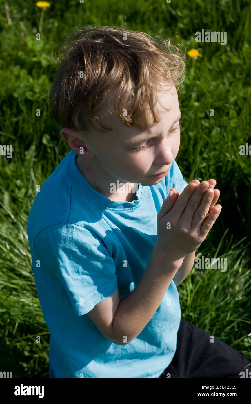 Junge im Feld zu beten Stockfoto