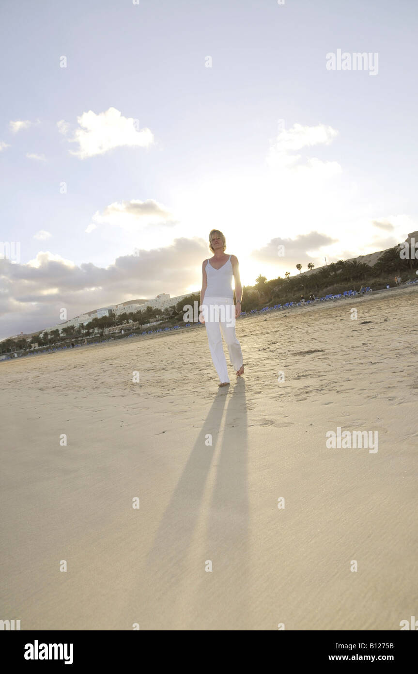 Hinterleuchtete Frau, stehend auf Sanddünen, in weiß gekleidet, Corralejo, Fuerteventura, Kanarische Inseln, Spanien, Europa Stockfoto