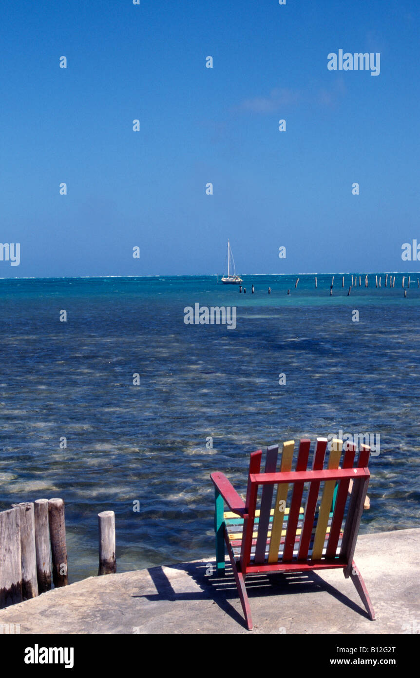 Wooden Liegestuhl mit Blick auf das blaue karibische Meer auf Caye Caulker, Belize, Central America Stockfoto