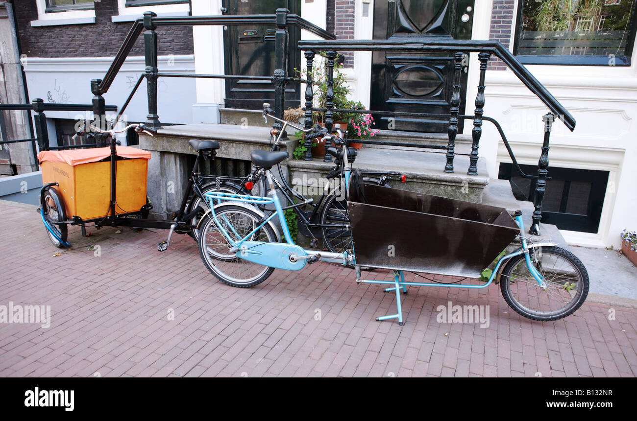 Fahrrad und Anhänger geparkt vor einem Haus in Amsterdam. Stockfoto