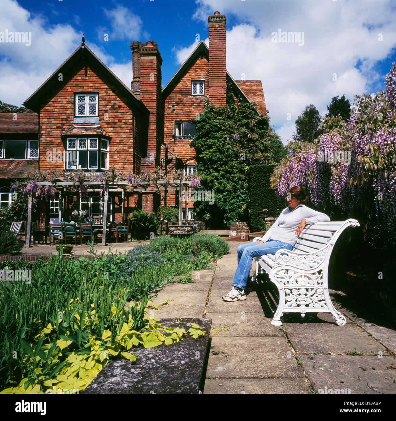 Frau in einem Garten Marle Ort Brenchley Nr Tonbridge Kent England UK entspannen. Stockfoto