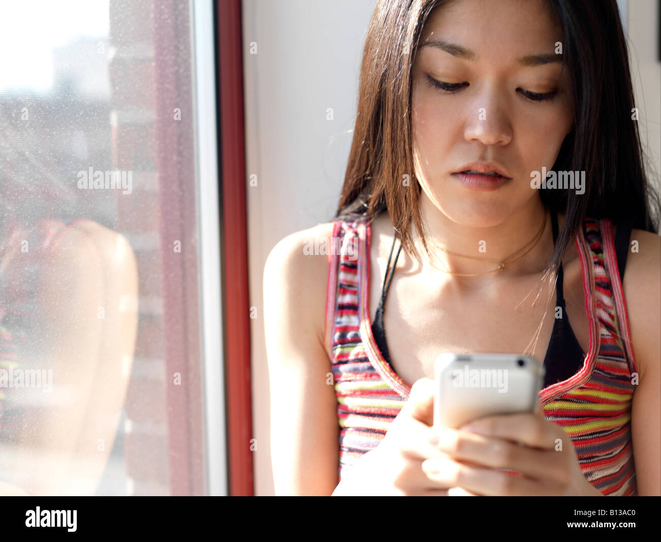 Junge asiatische Frauen mit Handy. Stockfoto