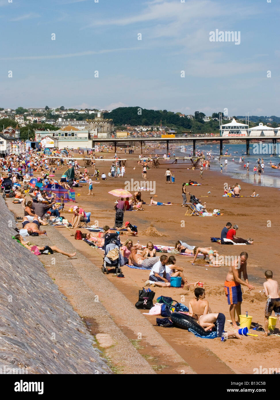 Urlauber genießen die Sommersonne am Strand und am Freizeitpier. Paignton, Devon, Großbritannien Stockfoto