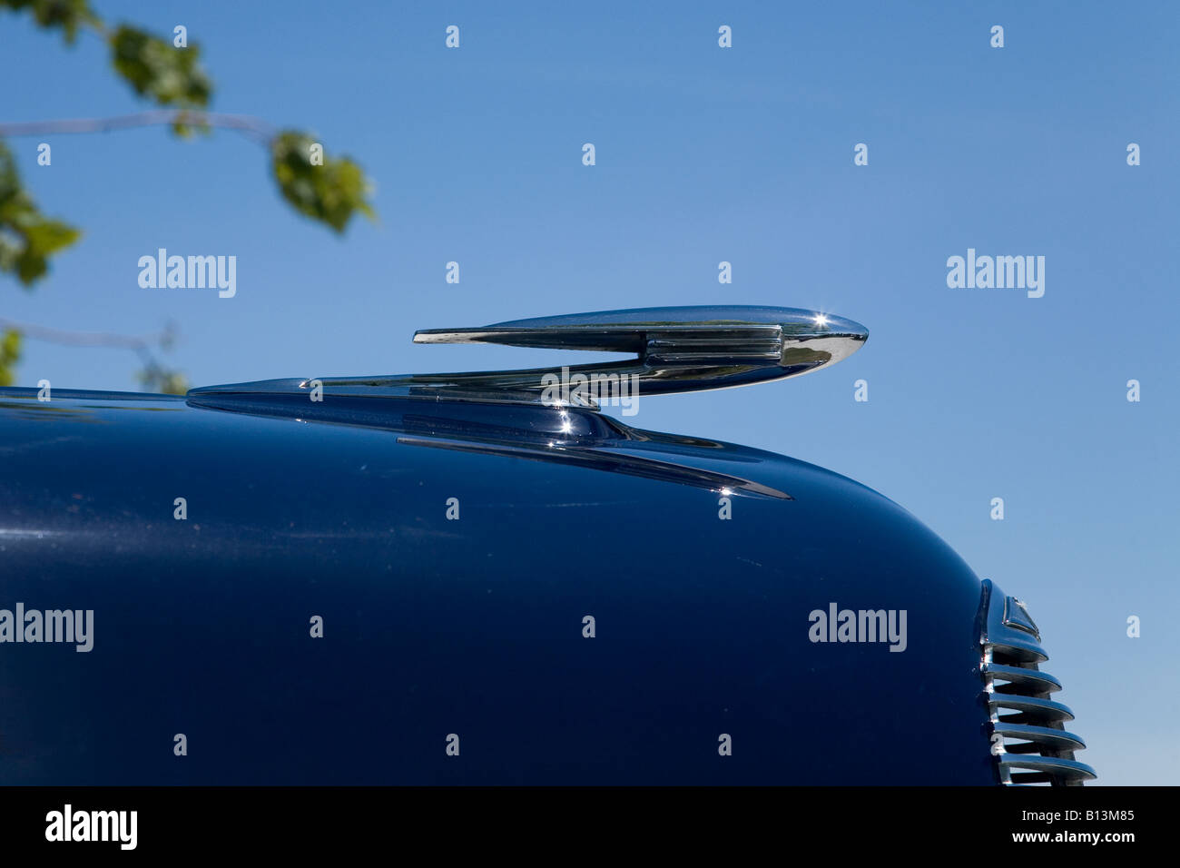 Foto eines blauen Oldtimers mit einer schönen Chrom-Kühlerfigur hautnah. Stockfoto