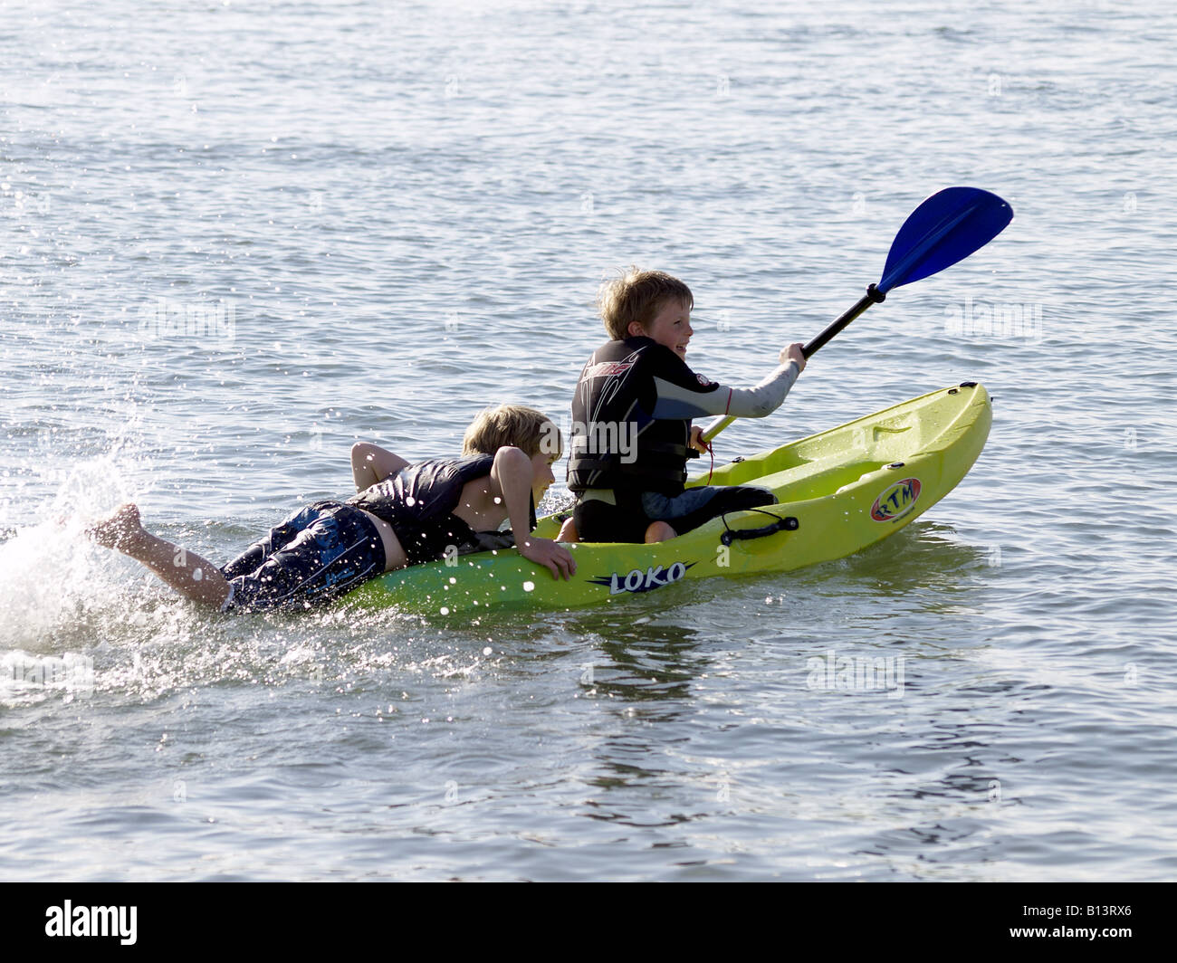 Zwei jungen tragen Schwimmhilfen, spielen auf einem Kajak Stockfoto