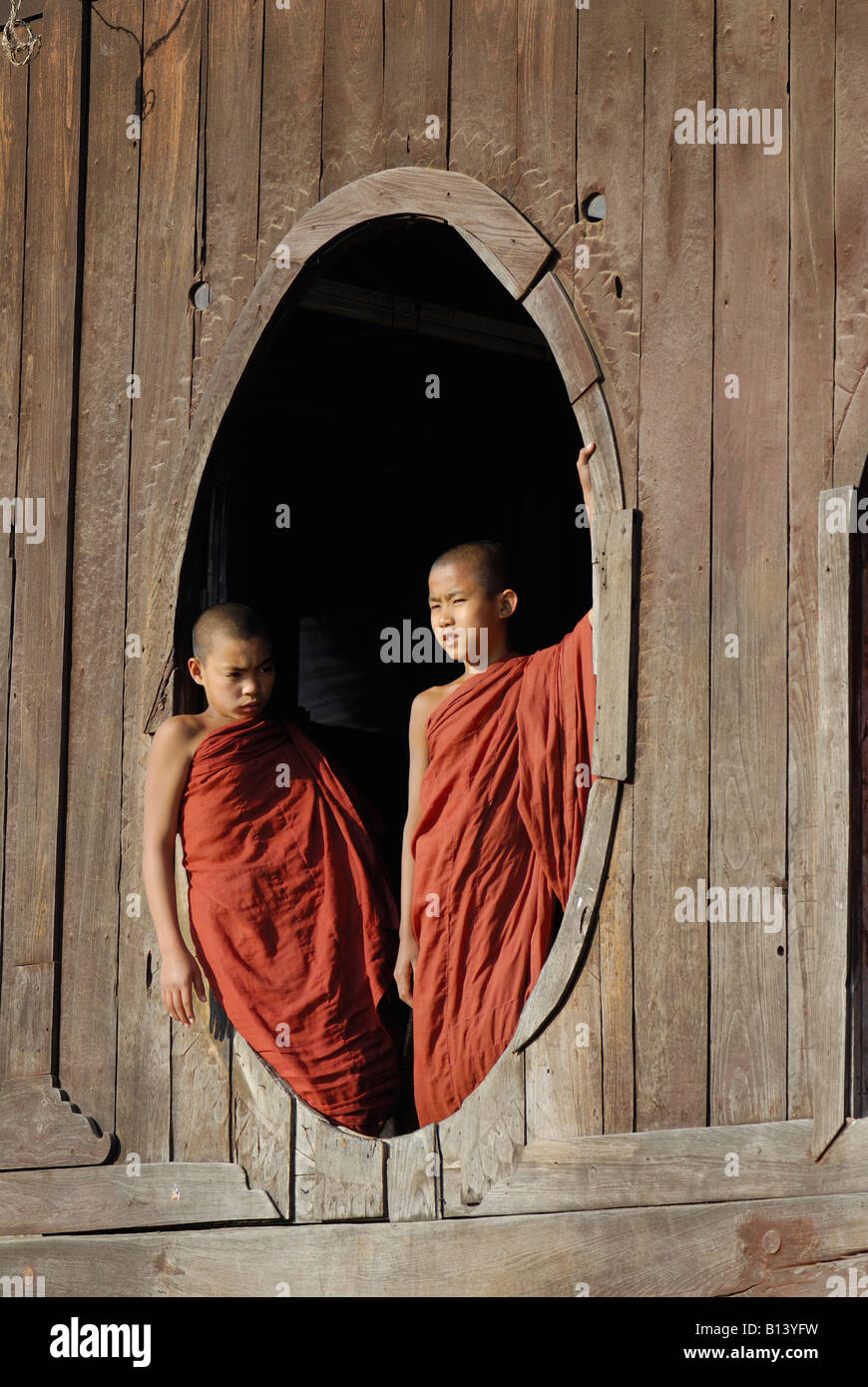 junge Mönche Blick aus einem Fenster im Shwe Yaungwe buddhistisches Kloster, Nyaungshwe, Inle See, MYANMAR BURMA BIRMA, Asien Stockfoto