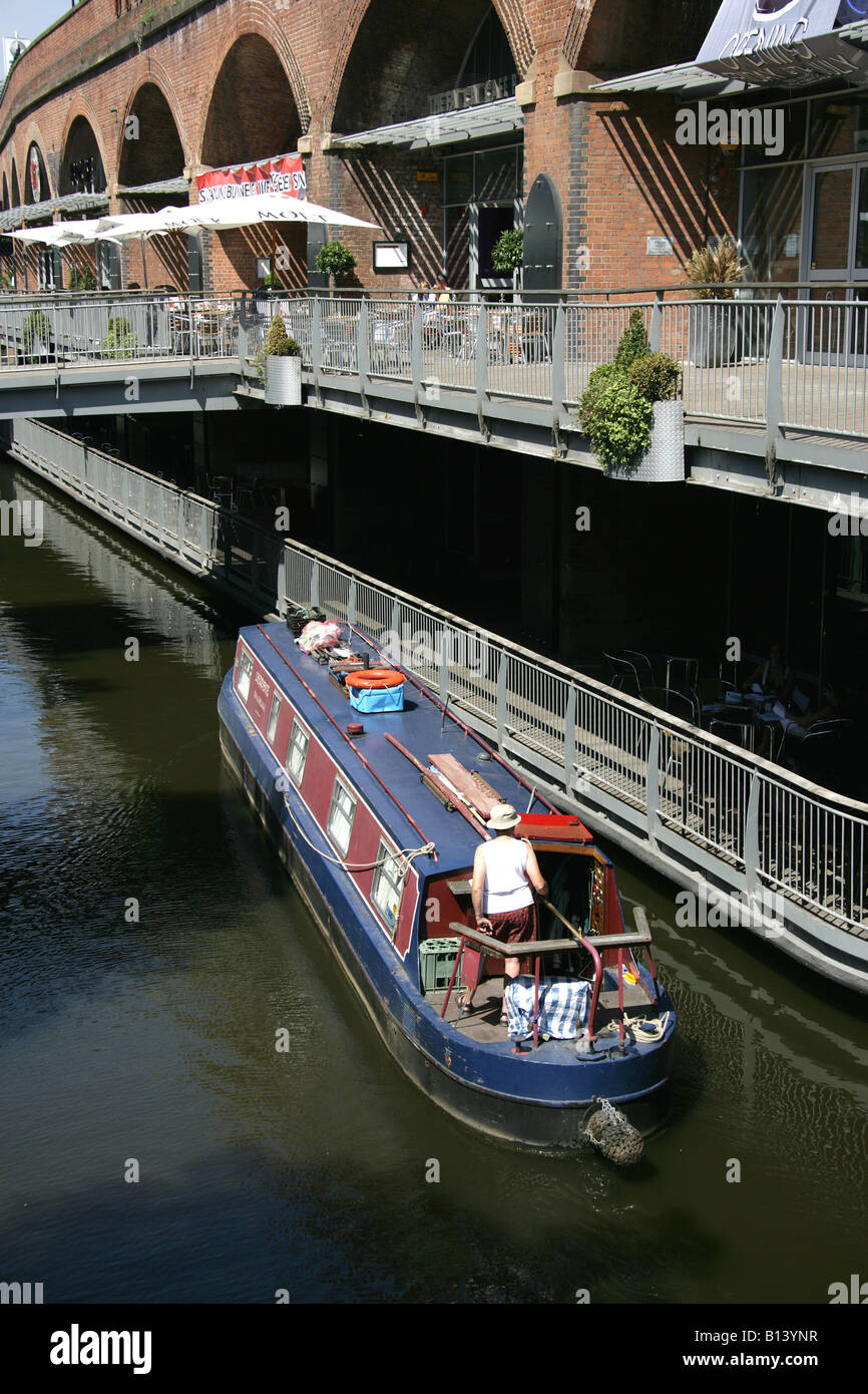 Stadt von Manchester, England. Kanalboote Whitworth Street mit Bars, Cafés und Restaurants im Hintergrund. Stockfoto