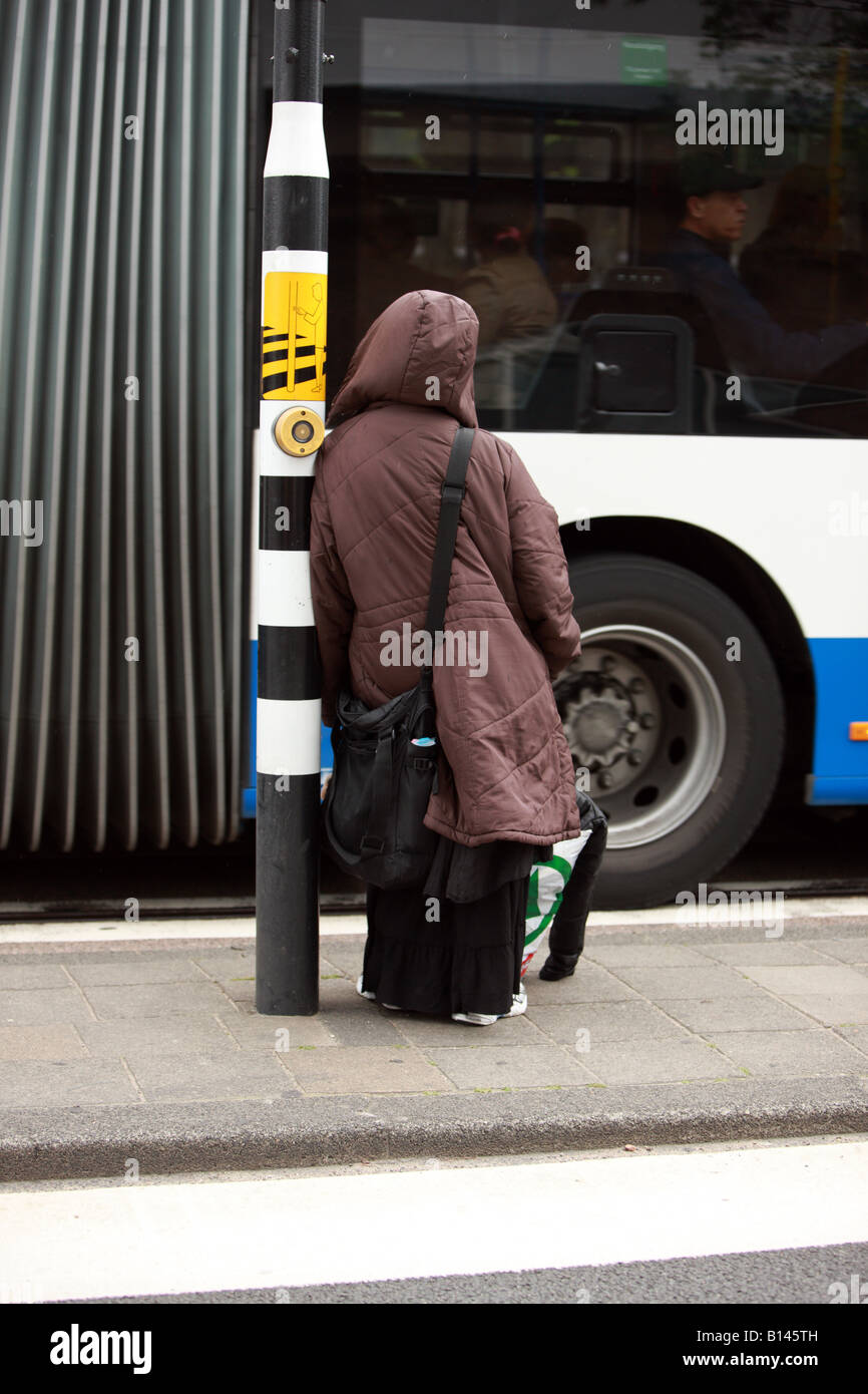 Einsam sucht individuelle, warten auf die befahrene Straße zu überqueren. Stockfoto