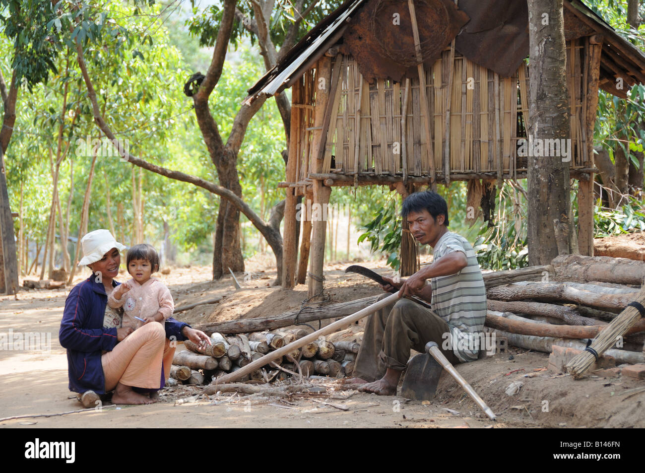 Vietnamesische Familienmutter Vater und Kind, die außerhalb ihres einfachen Stielhauses Central Highlands Vietnam arbeiten Stockfoto