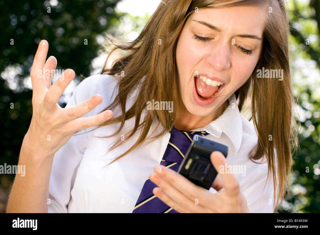 Mädchen schockiert über die Nachricht am Telefon Stockfoto