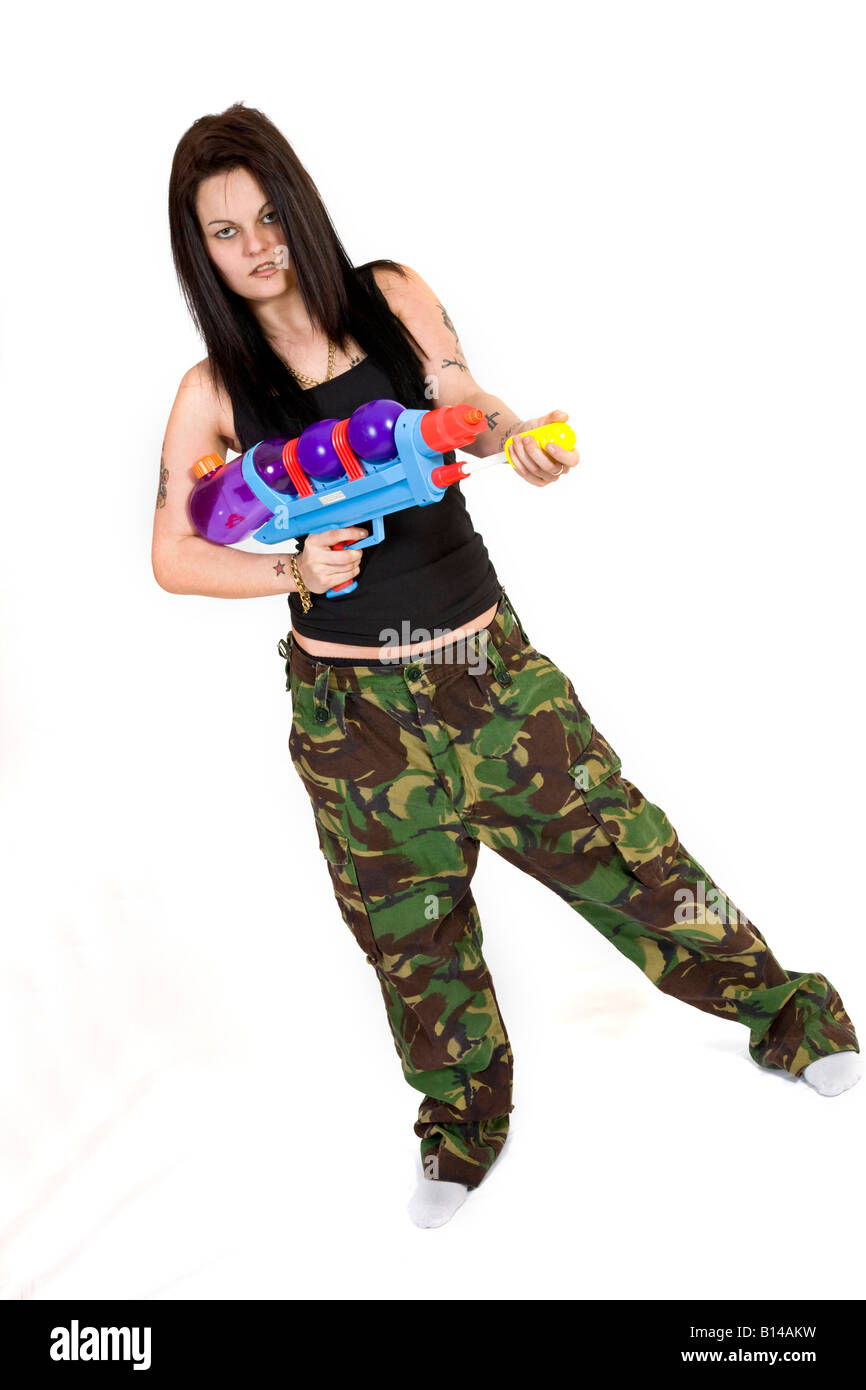 Eine Frau im Kampf gegen Hosen und eine schwarze Weste Oberseite hält eine Super Soaker Wasserpistole. Stockfoto