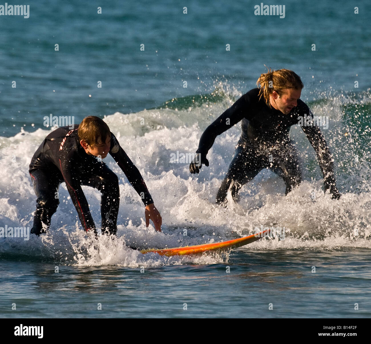 Männliche Surfer bei Sennen in Cornwall. Stockfoto