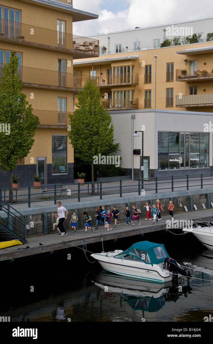 Lehrer führt eine Klasse von sehr jungen Kindern auf eine Übung führen Sie durch modernste Stadtteil Hammarby Stockholm Stockfoto