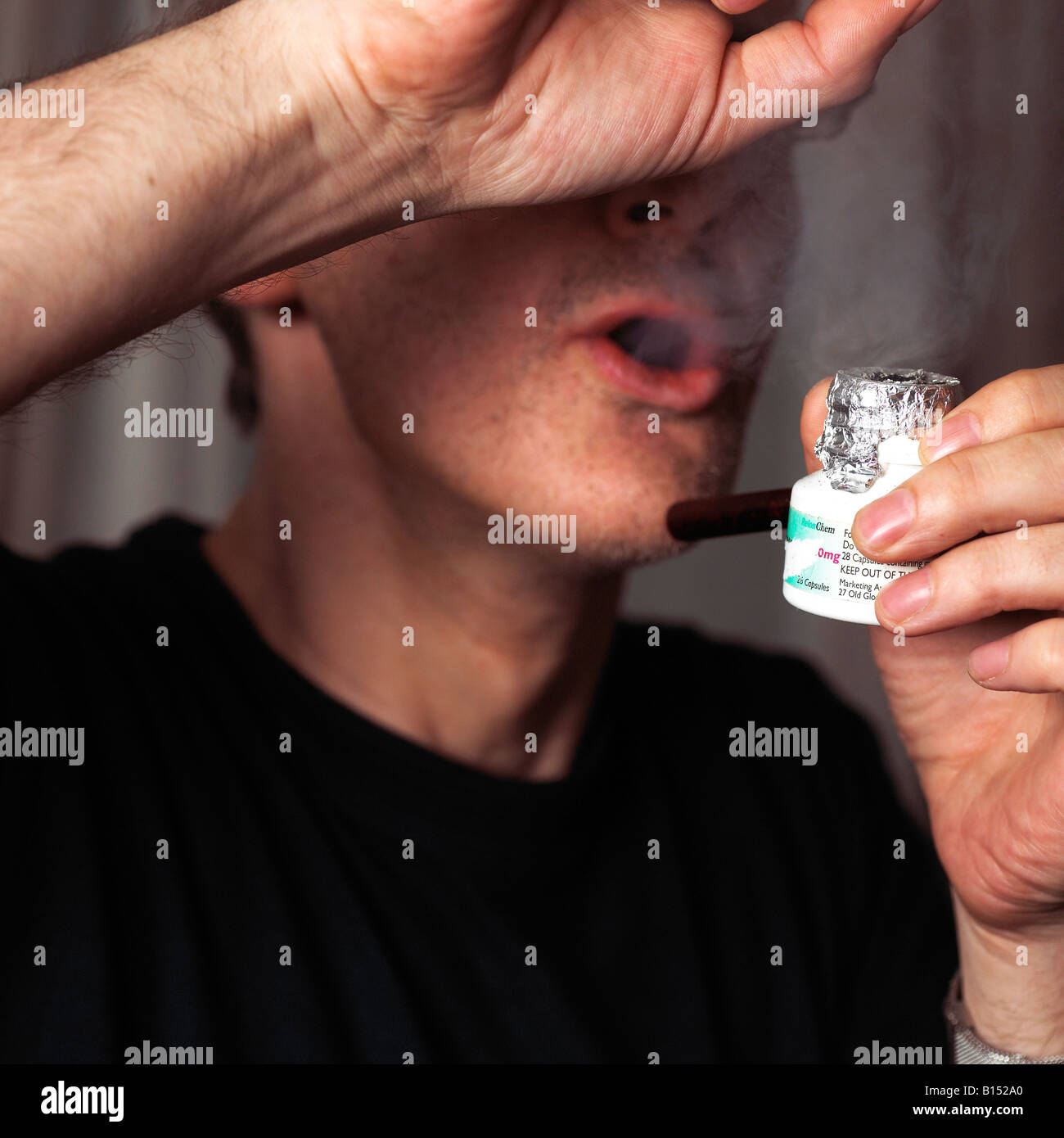 Mann Rauchen Crack-Kokain aus einem Rohr Stockfoto