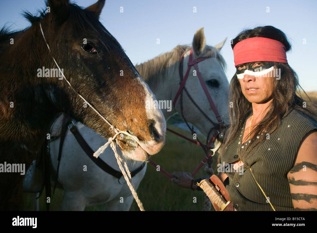 Native American Apache Indian in Kriegsbemalung mit seinen Pferden Stockfoto