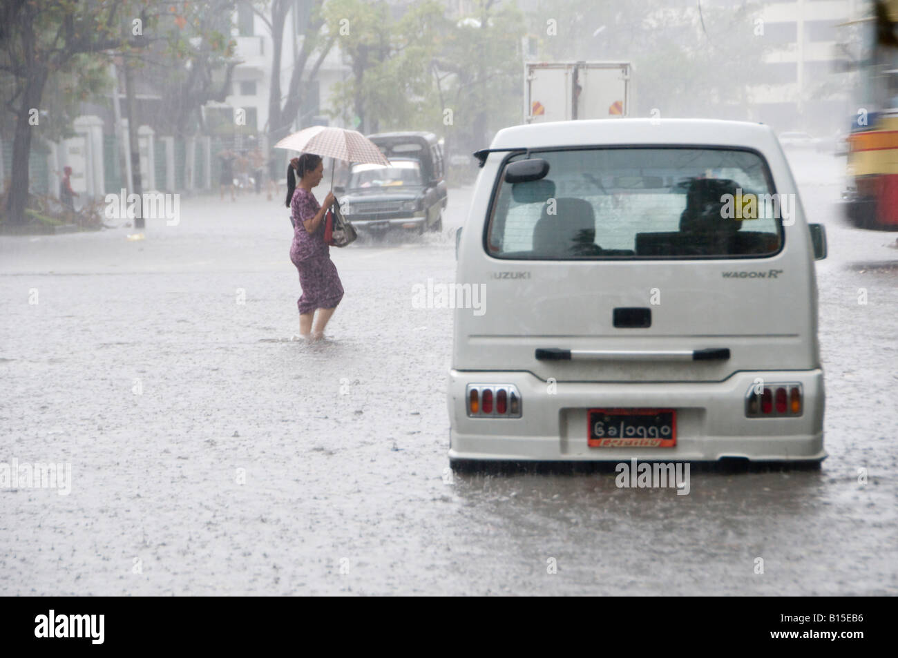 Ein Fußgänger geht in eine überflutete Straße im Zentrum von Yangon aufgrund reichlich Niederschlag, Myanmar, Birma Stockfoto