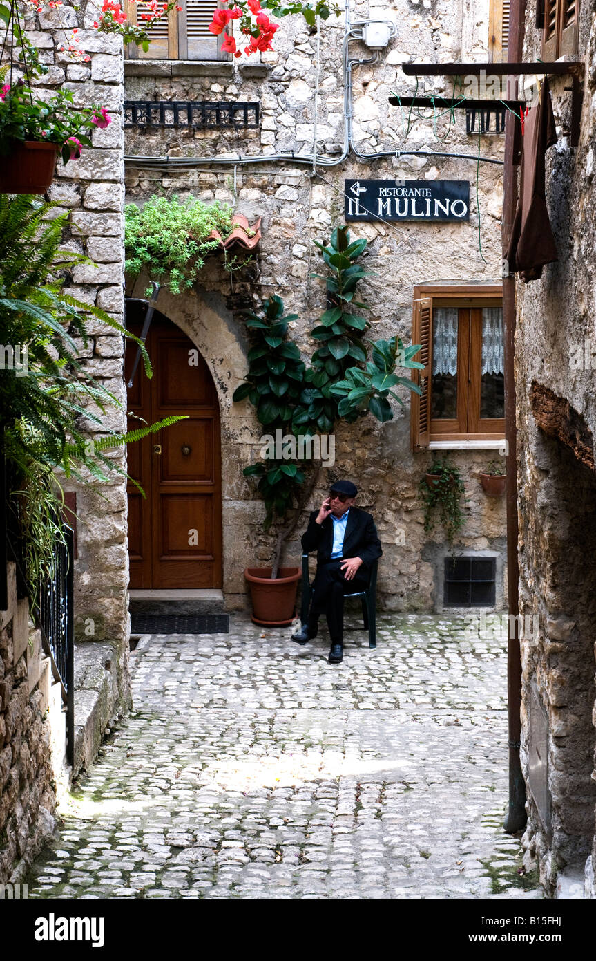 Alter Mann sitzt vor seinem Haus in Sermoneta, Italien Stockfoto