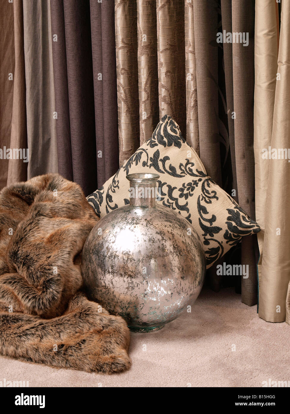 Kombination von trendigen modernen Einrichtungsgegenstände in grauen Braunerde Farben Vase Fell Vorhänge Vorhänge Kissen Stockfoto