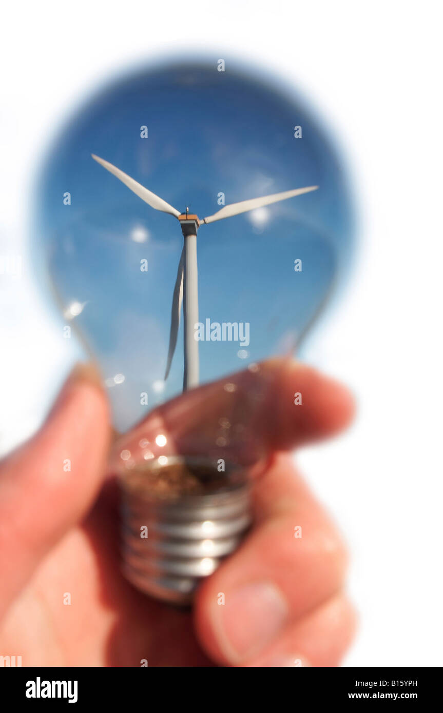 Windkraftanlage im blauen Himmel durch Hand mit Glühbirne. Isoliert auf weiss. Stockfoto