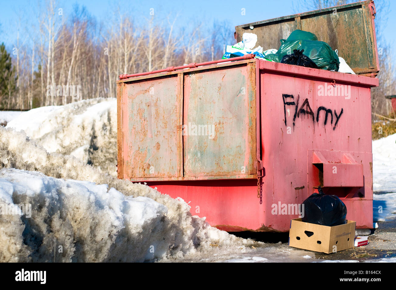 Eine große rote Mülltonne überfüllt mit Müllbeutel Stockfoto