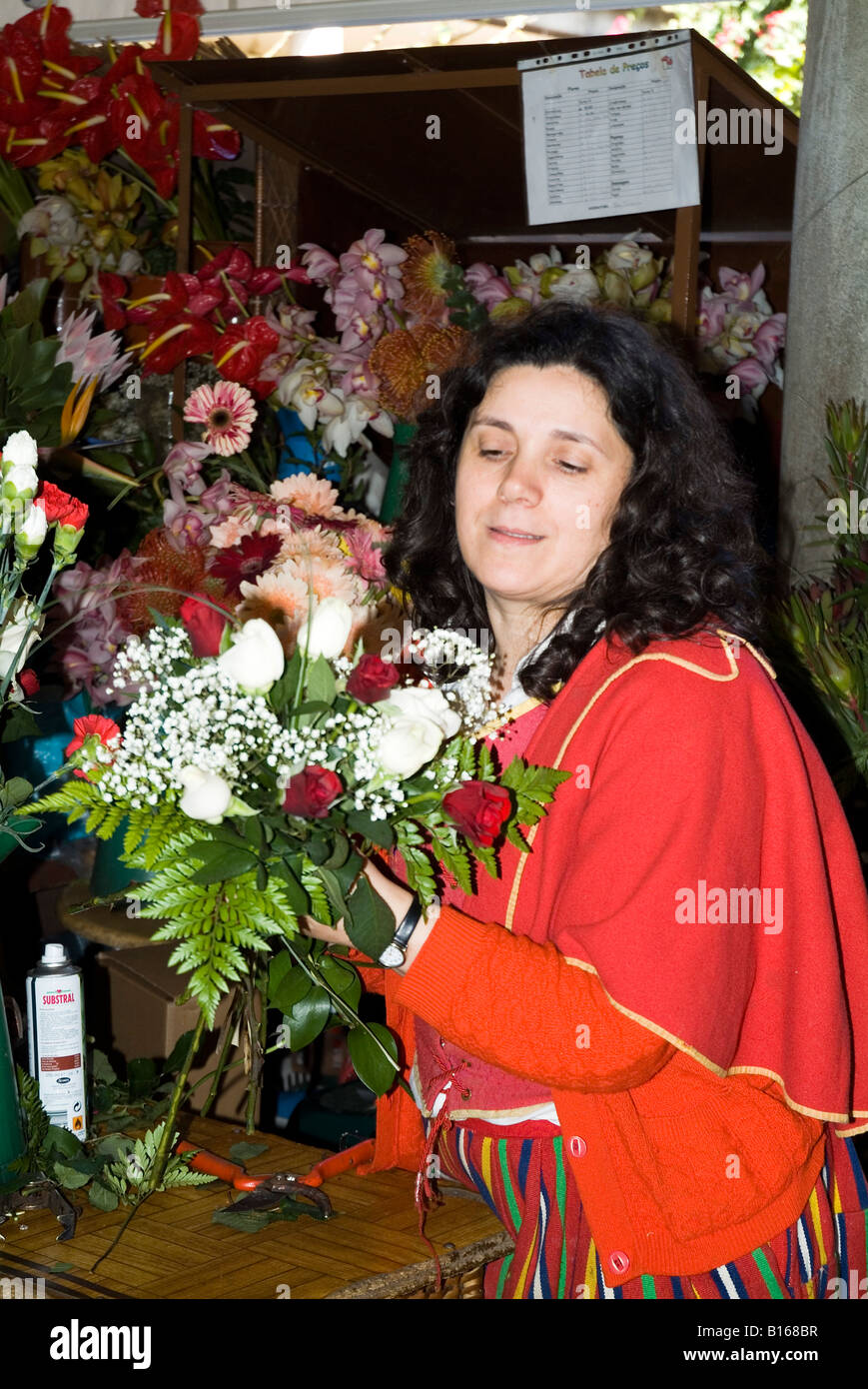 dh Mercado Dos Lavradores FUNCHAL MADEIRA Flowerseller in Tracht arrangieren Haufen von Blumen Stockfoto