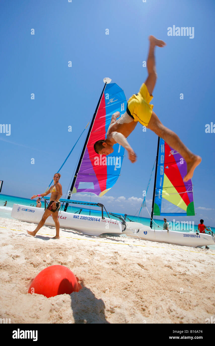 Mann am mexikanischen Strand mit einer Boje als ein Trampolin in die Luft springen. Stockfoto