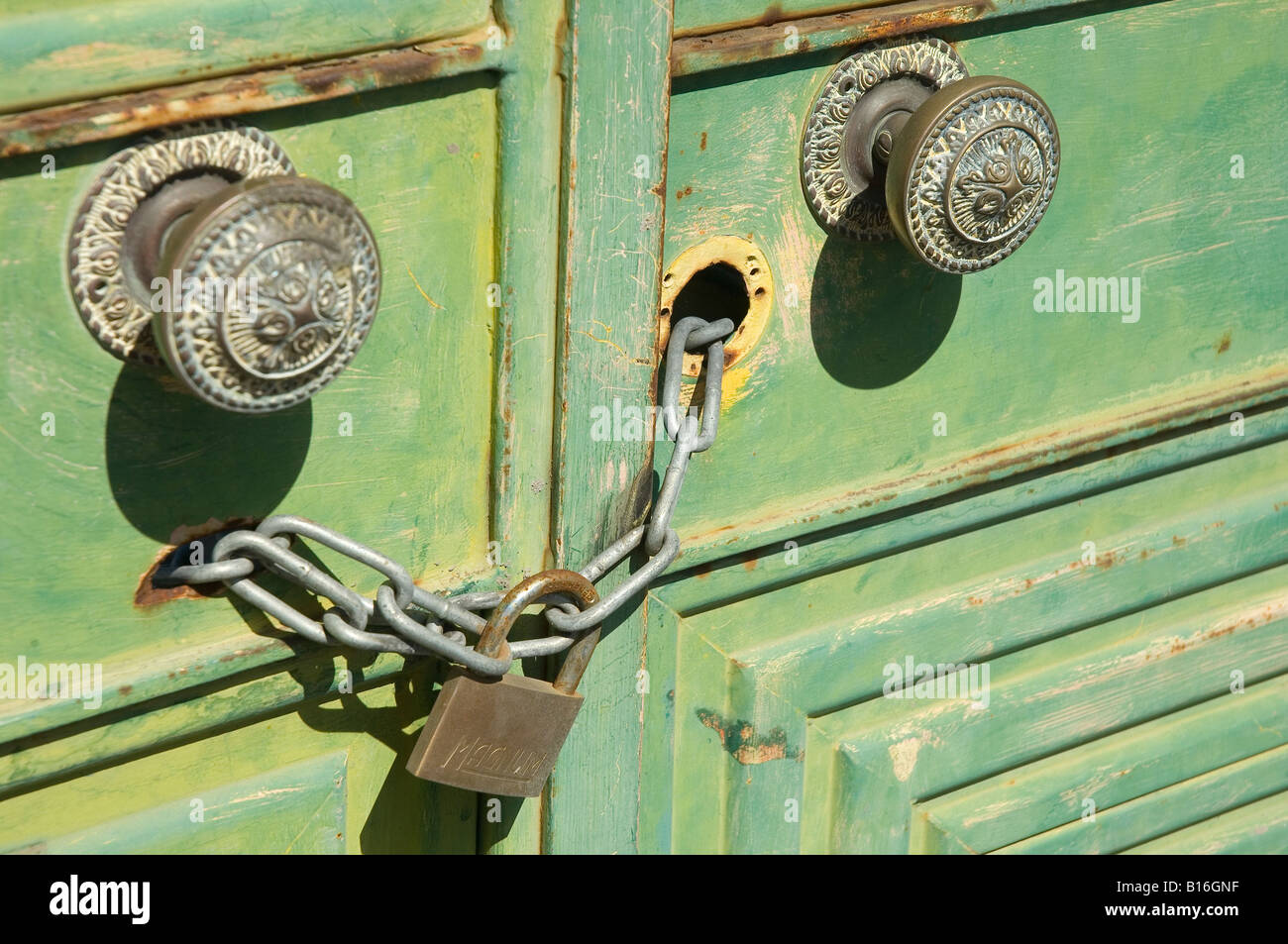 Türgriffe Vorhängeschloss und Kette auf alten grün Metall Türen schließen nach oben Stockfoto