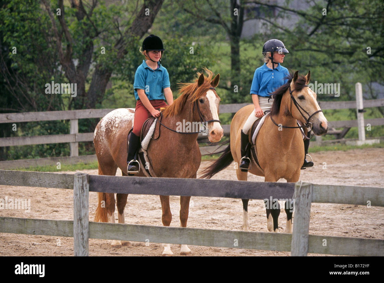 Zwei junge Pre Teen Mädchen gekleidet in der Kleidung Praxis Dresage auf ihren Pferden reiten Stockfoto