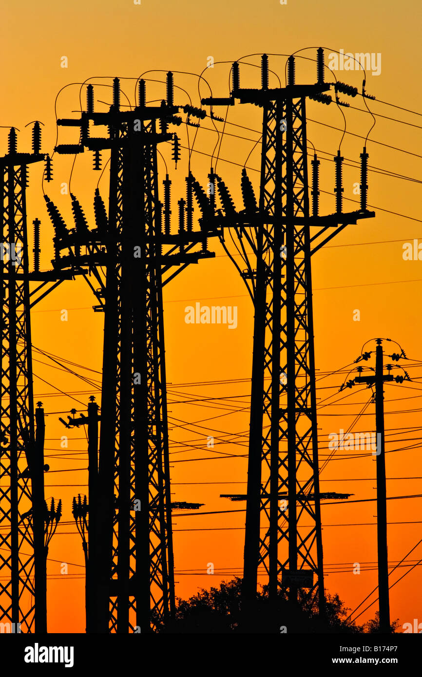 Energiewirtschaft / Strom. Eine hohe Spannung Fernmeldeturm Silhouette bei Sonnenuntergang. Stockfoto