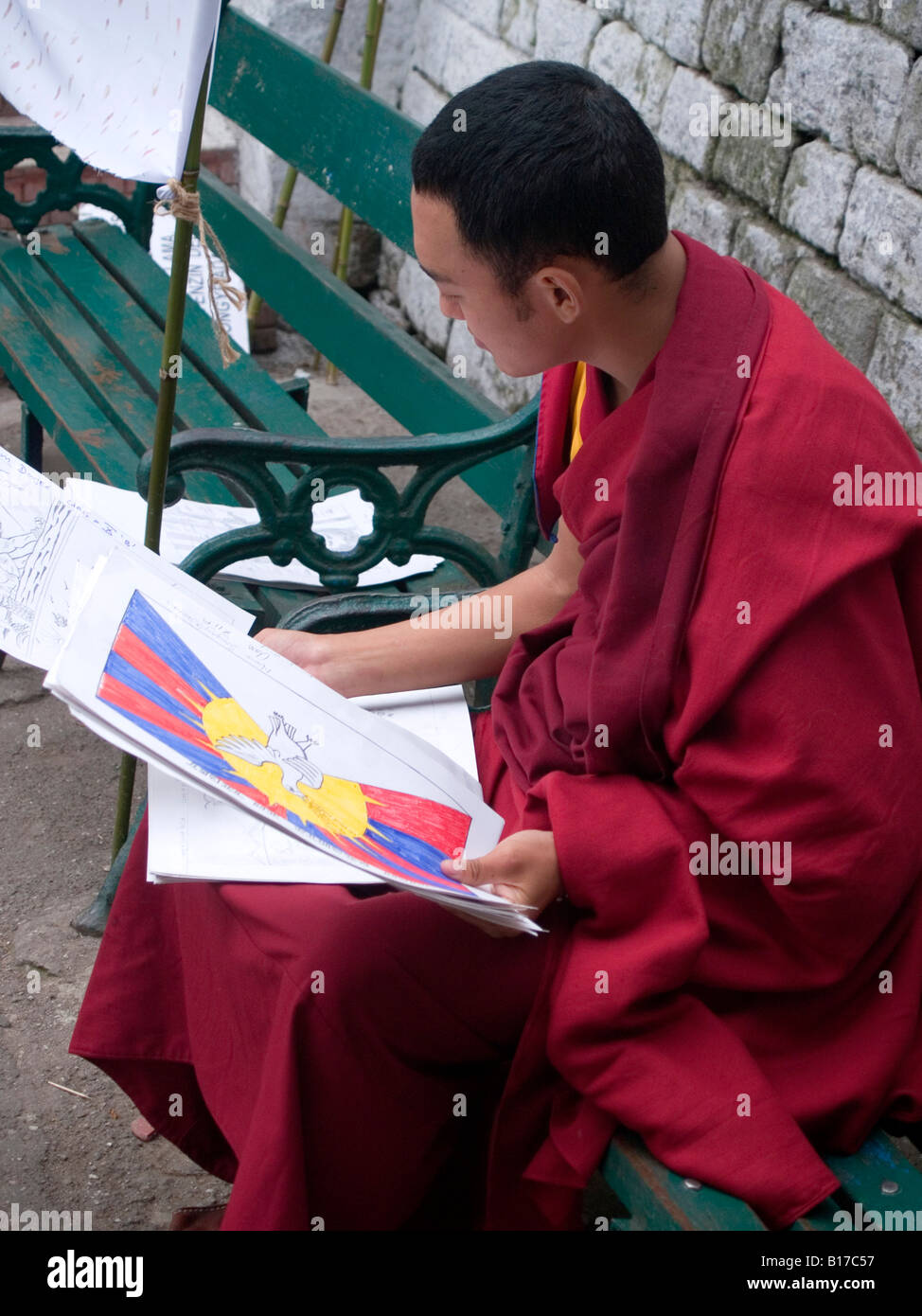 Tibetischer Mönch Blick auf Kunstwerke von Schülern in Darjeeling Stockfoto