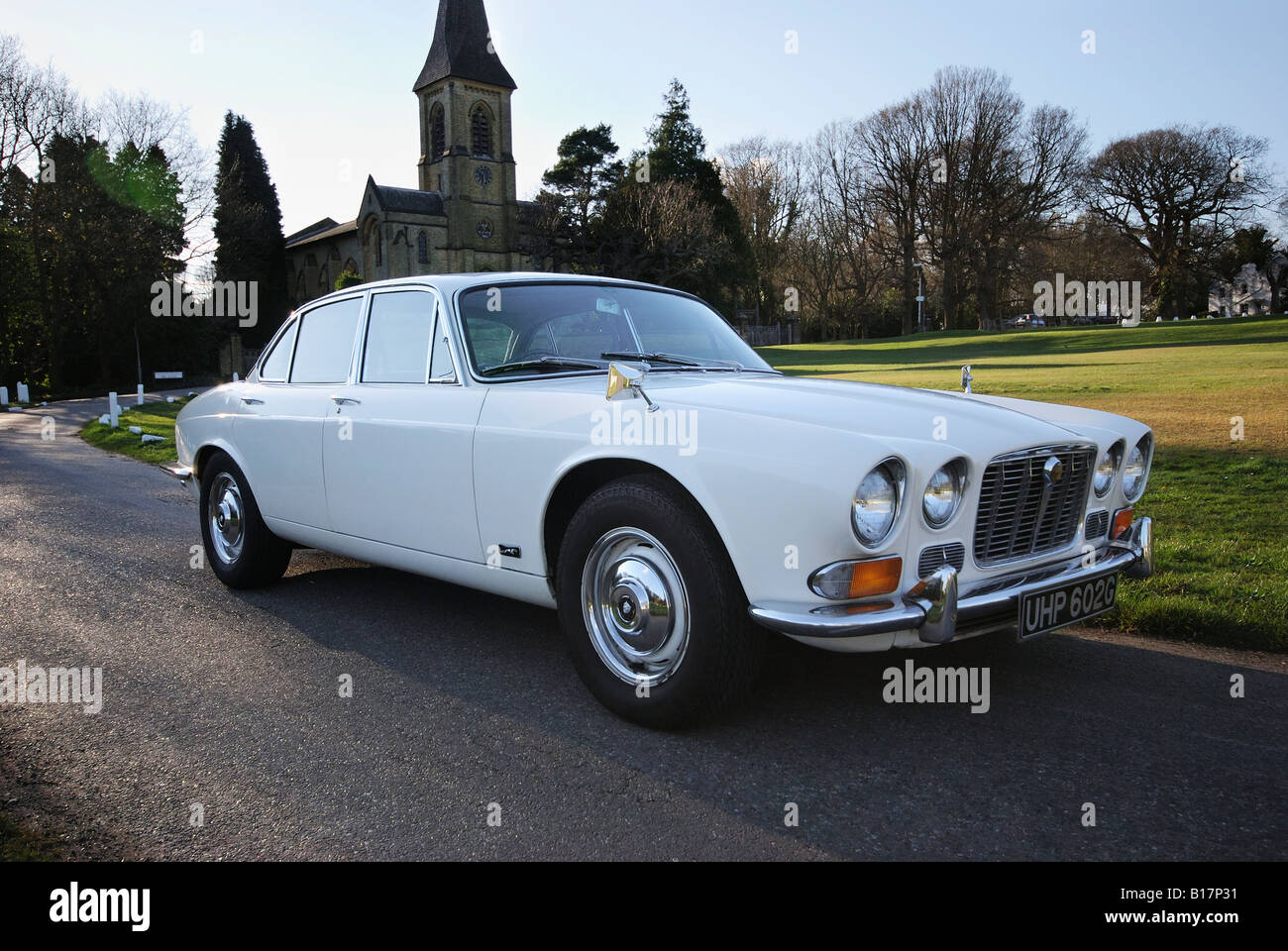 England, Kent, Southborough, 1969 weiße Jaguar Auto XJ6 geparkt auf Landstraße, Kirche im Hintergrund Stockfoto