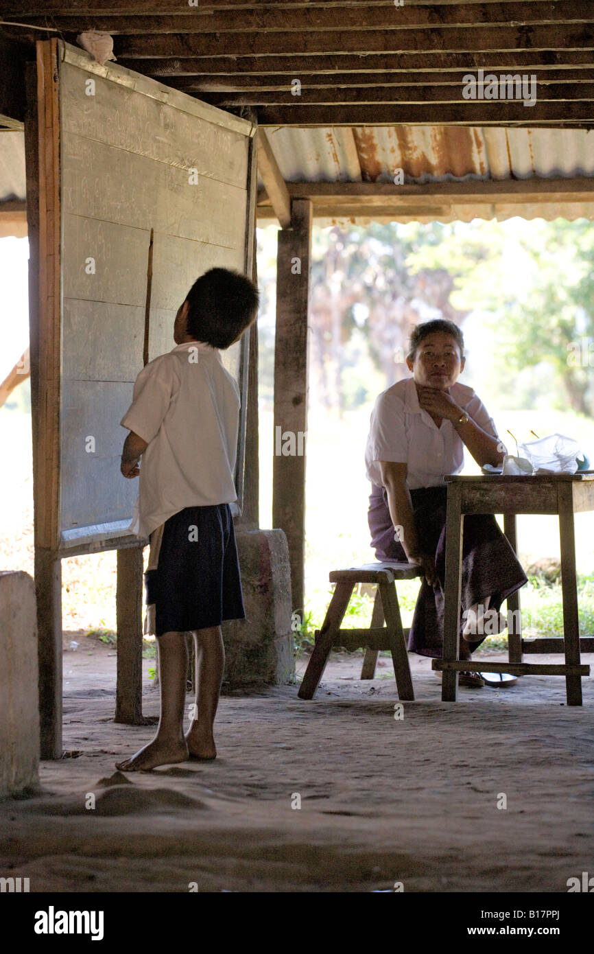 Lao Schuljunge rezitiert Unterricht an der Tafel beim Treacher Uhren, Südlaos Stockfoto